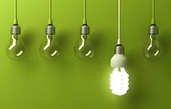 5 lightbulbs hanging in front of green background, one is lit up