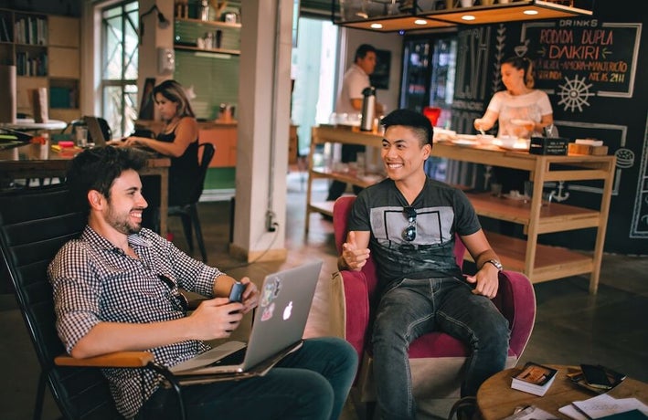 modern workplace with colleagues sitting alongside each other and a bar in the back