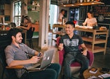 modern workplace with colleagues sitting alongside each other and a bar in the back