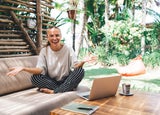 Woman sat working on a beach