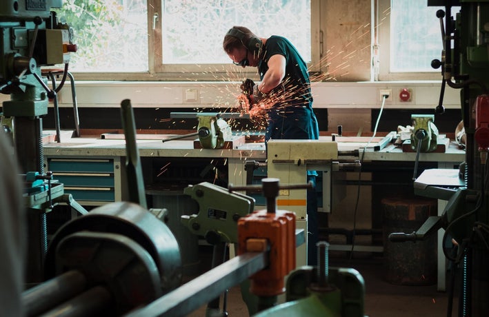 A man using a grinder in a workshop