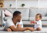 Shared Parental Leave. Young Black Father Playing With Little Baby At Home